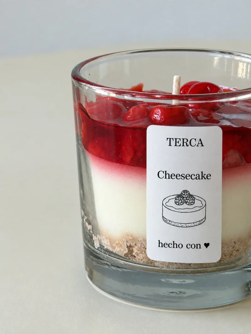 Detalle de las tres capas de la vela TERCA Cheesecake: galleta, crema y frutos rojos